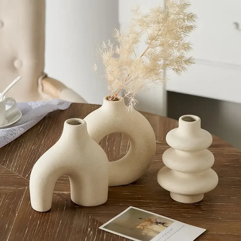 Arch, ring and stacked bisque ceramic vases on a table