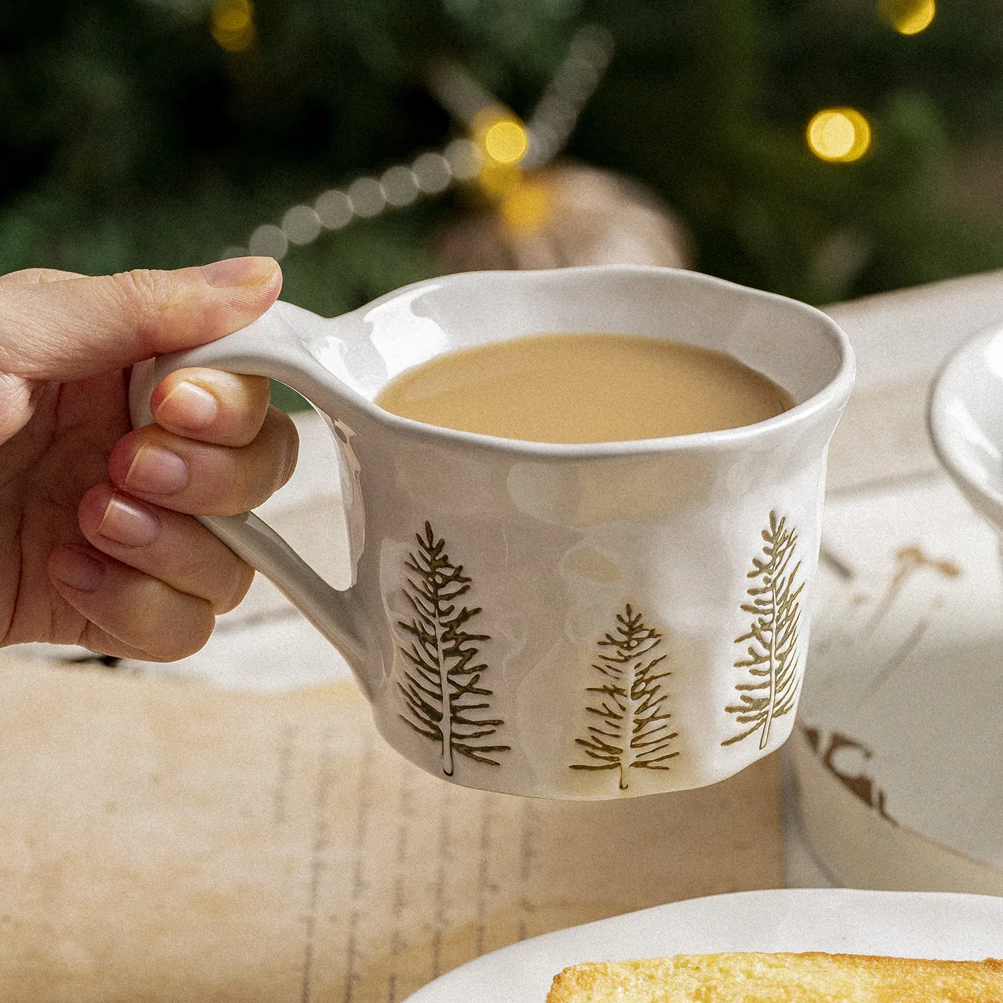 White Christmas tree ceramic mug held by its handle