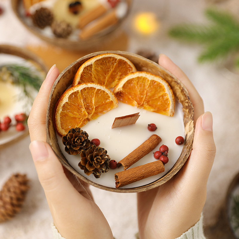 Coconut bowl candle with dried orange, cinnamon and pinecones