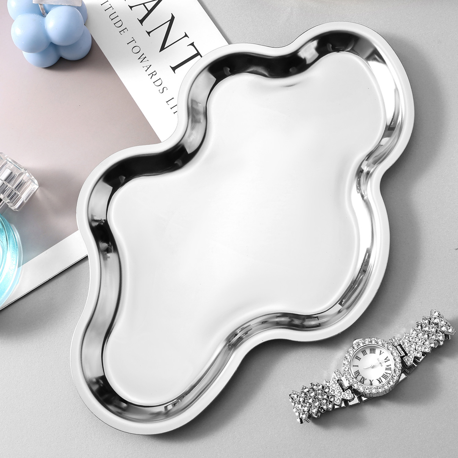 Silver cloud-shaped tray styled with jewelry