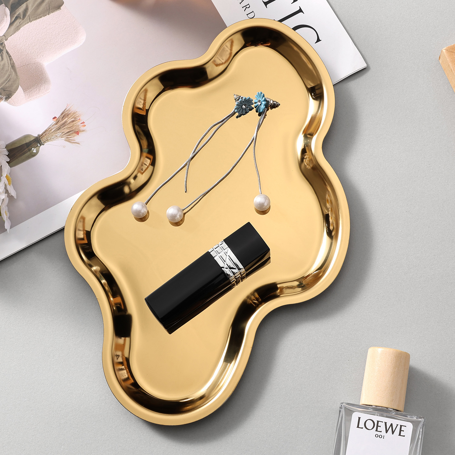 Gold cloud-shaped tray holding jewelry and cosmetics