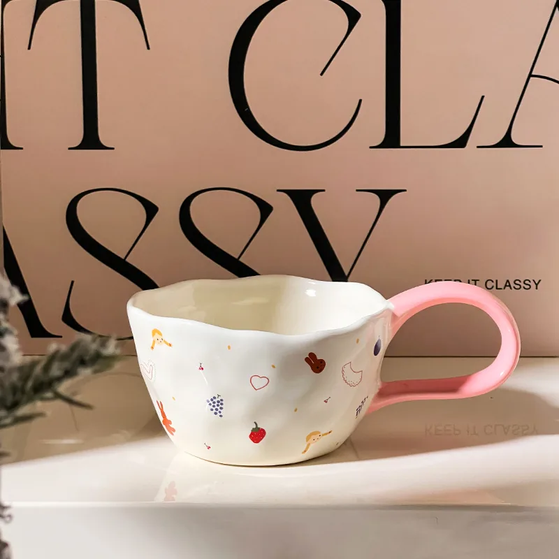 White illustrated ceramic mug with pink loop handle