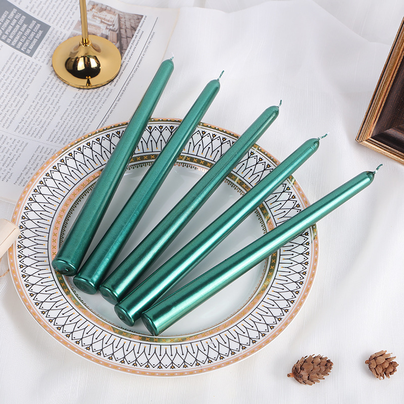 Green classic taper candles arranged on a decorative plate