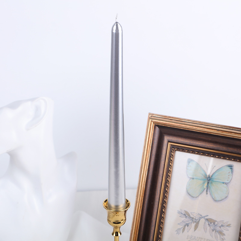 Silver classic taper candle displayed in a gold holder
