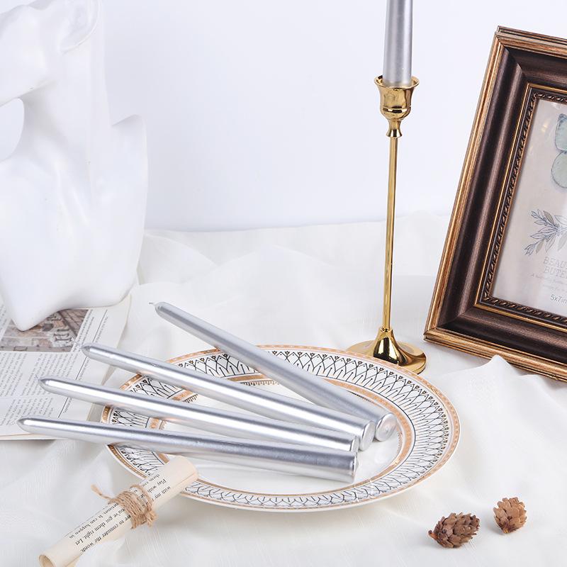 Silver taper candles arranged with a candle holder