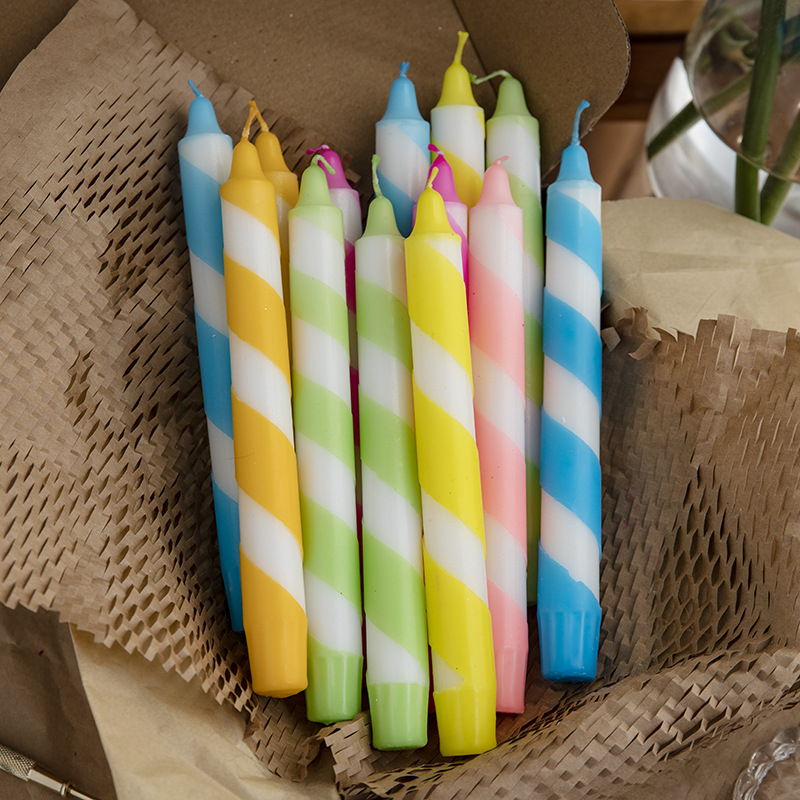 Assorted colorful spiral striped taper candles in packaging