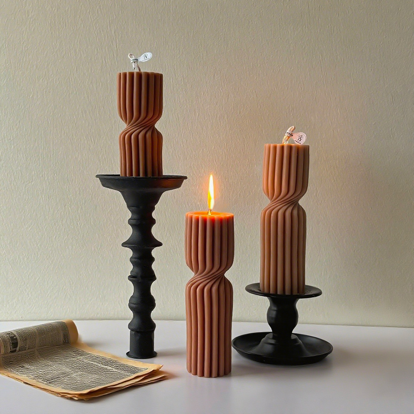 Ribbed hourglass candles shown lit and unlit