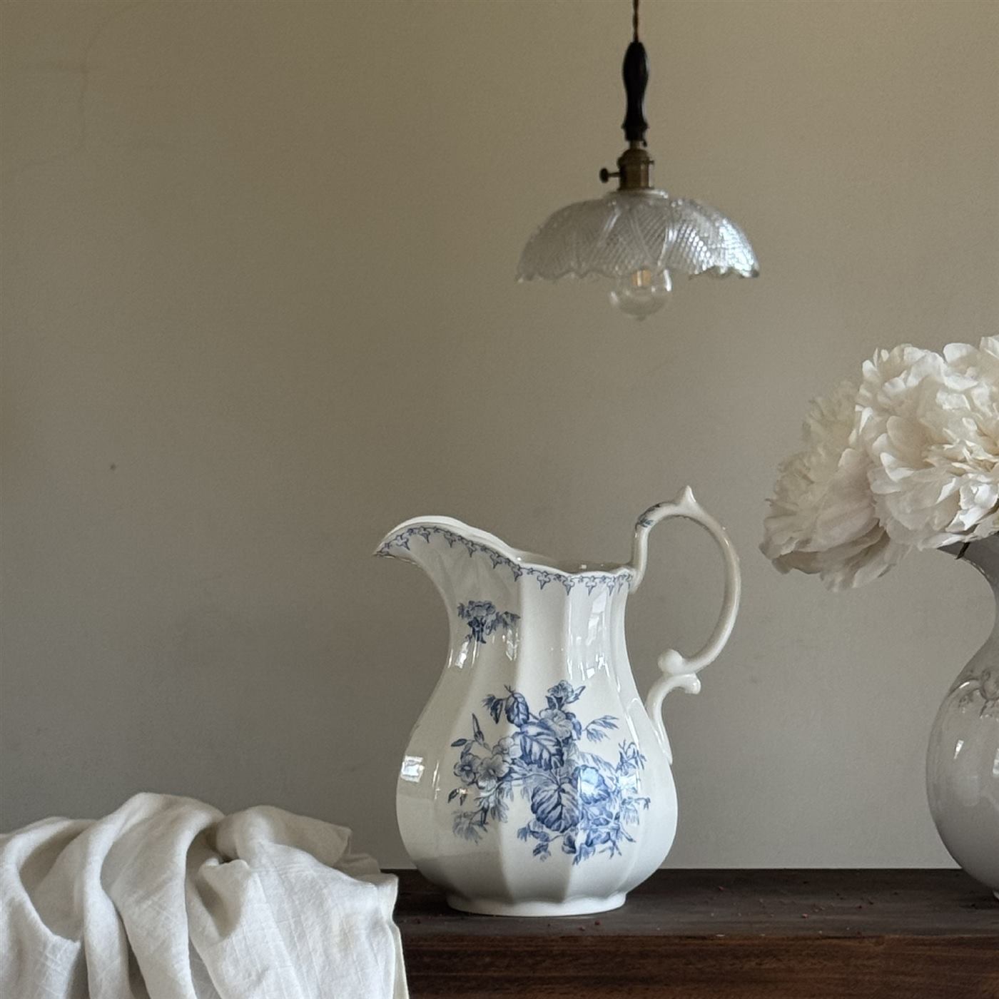 Fluted ceramic vase with blue floral decoration on a shelf