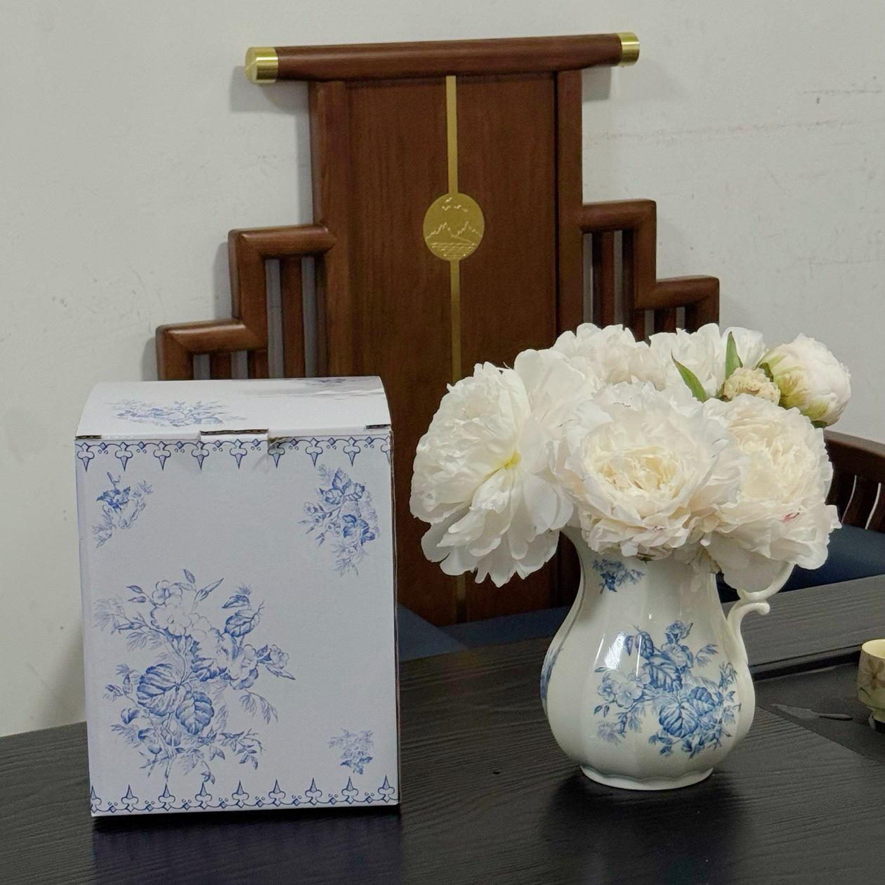 Floral ceramic vase displayed beside its matching printed box