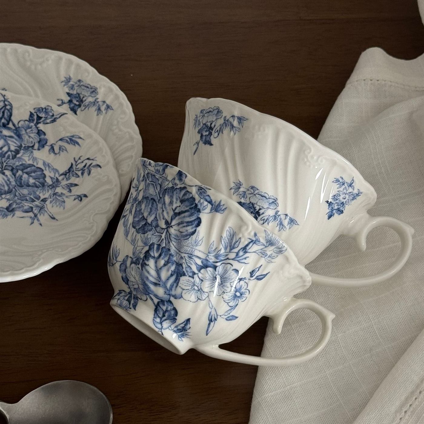 Close view of blue floral ceramic cups and matching saucers