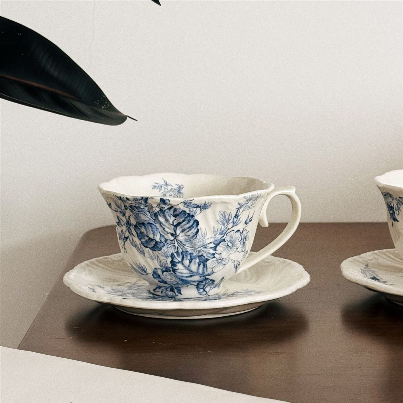 Detailed blue floral ceramic coffee cup with matching saucer