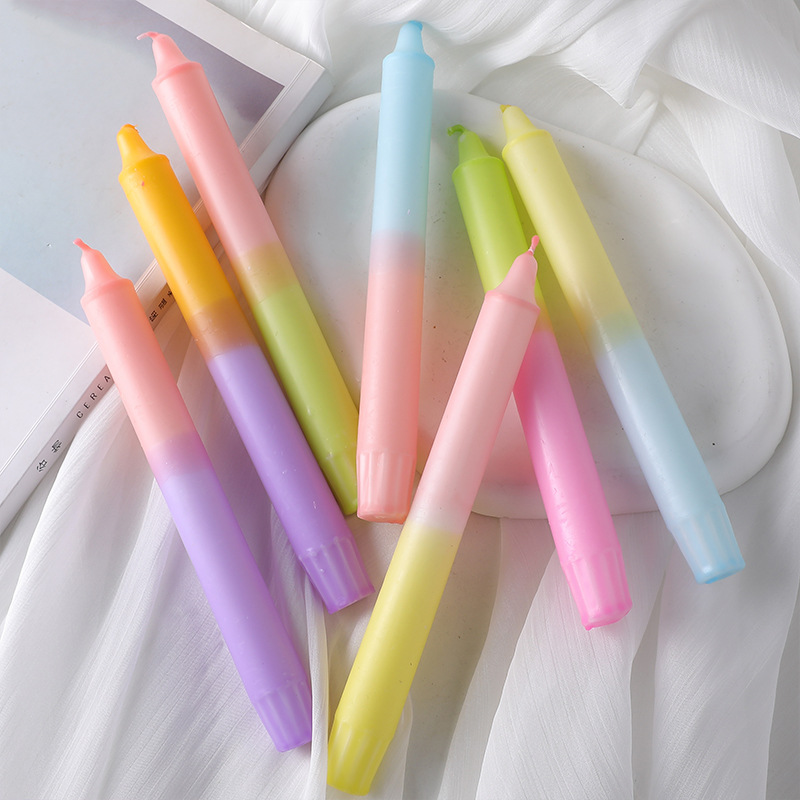 Assorted pastel gradient taper candles arranged on a tray