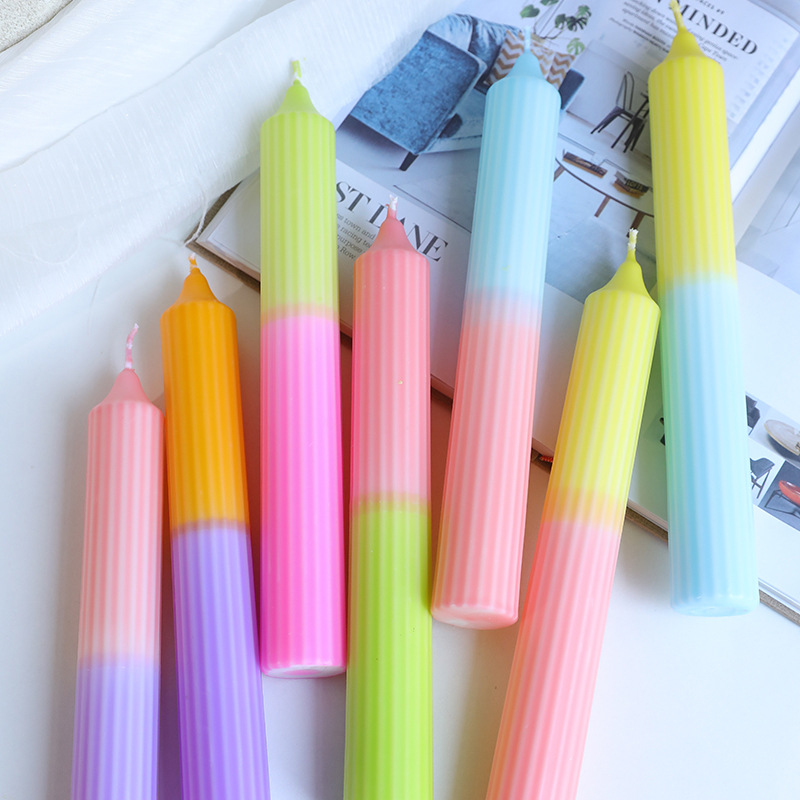 Assorted gradient ribbed taper candles arranged on a table