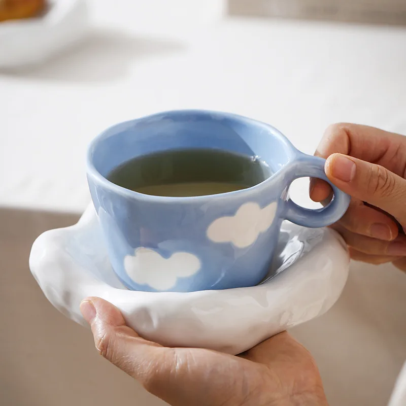 Cloud cup and saucer held by hand
