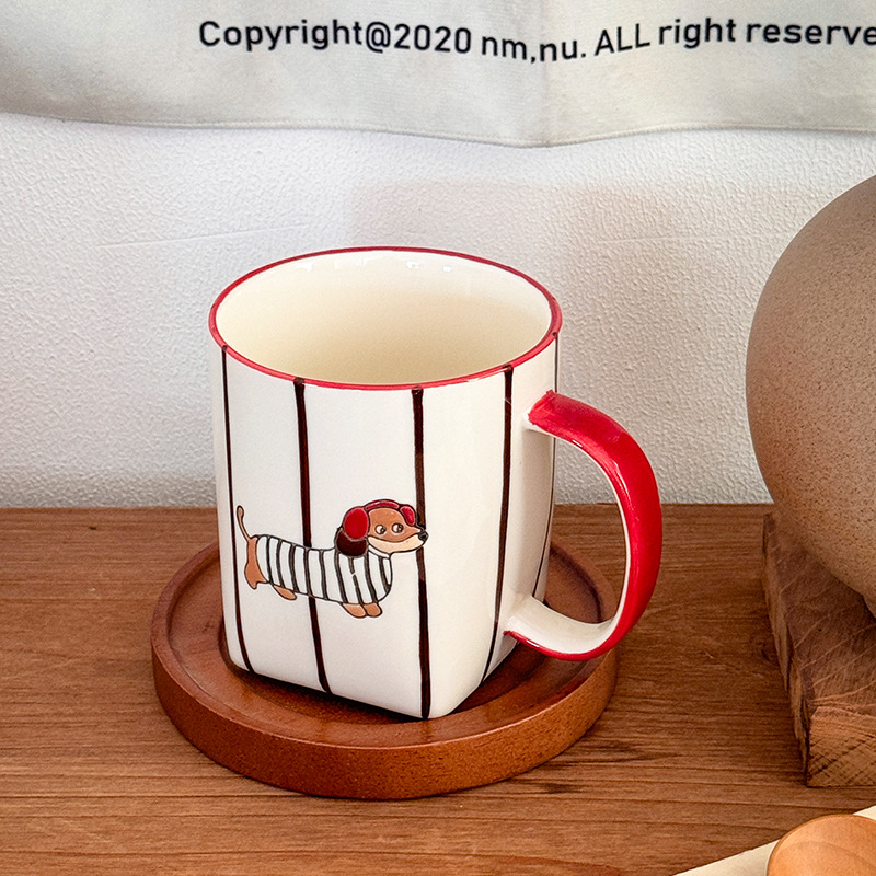 Red dachshund ceramic mug on a wooden coaster