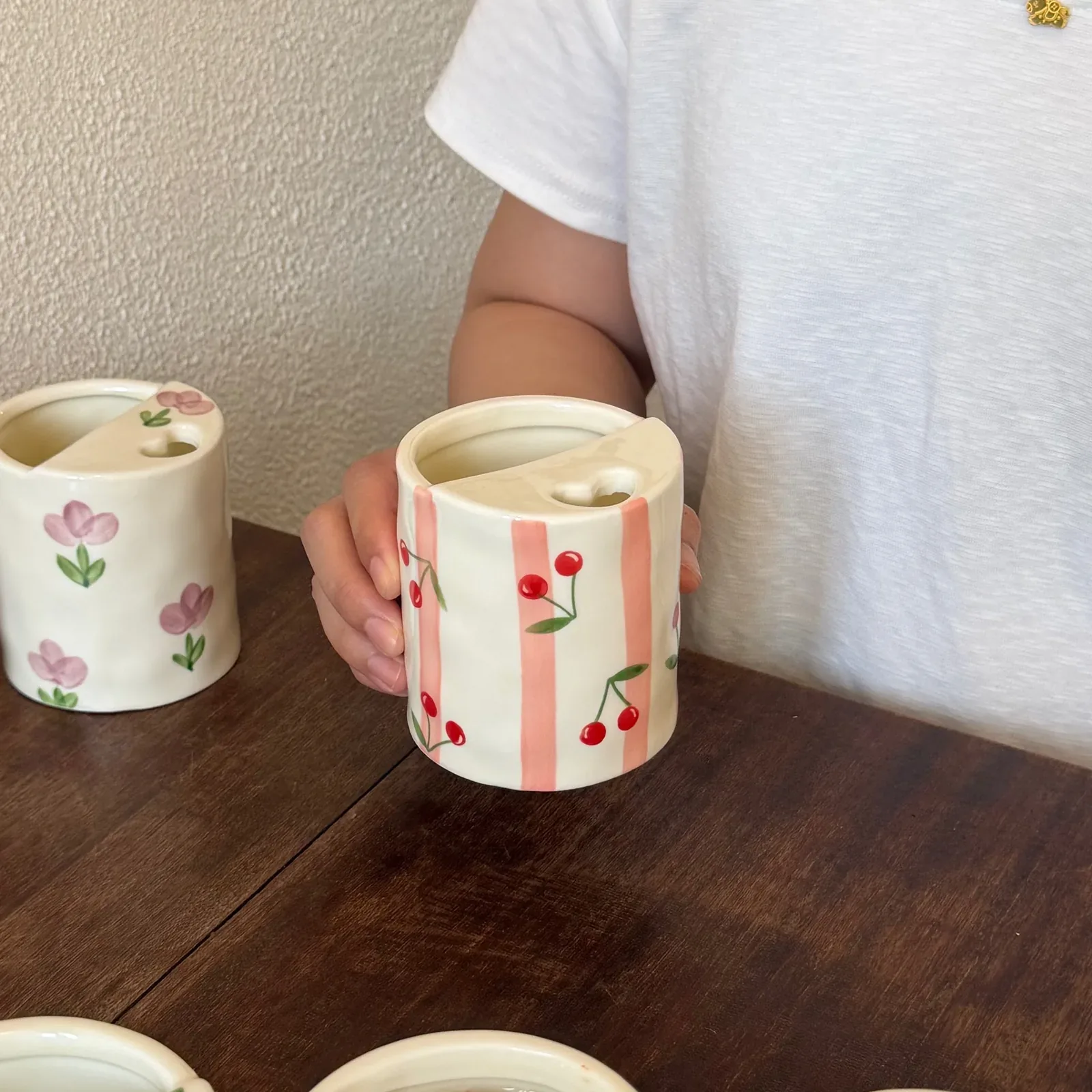 Pink stripe cherry mug held by hand