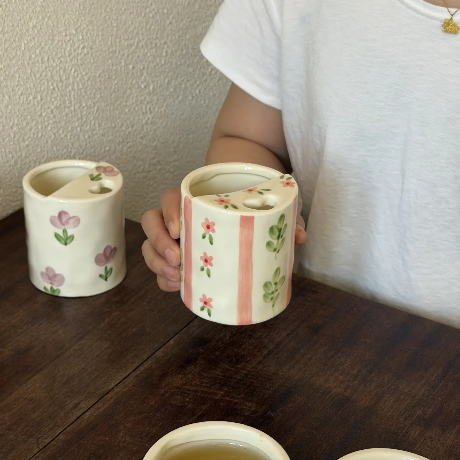 Pink stripe floral mug held by hand