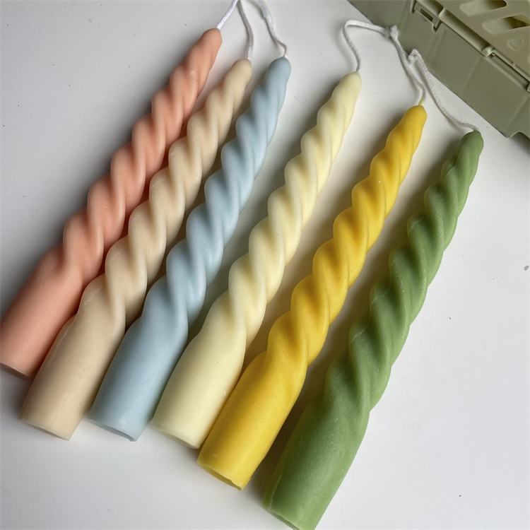 Six handmade spiral candles displayed in a row