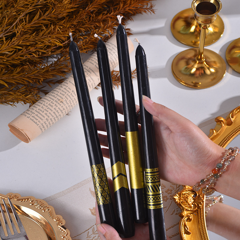 Black taper candles with assorted metallic gold patterns