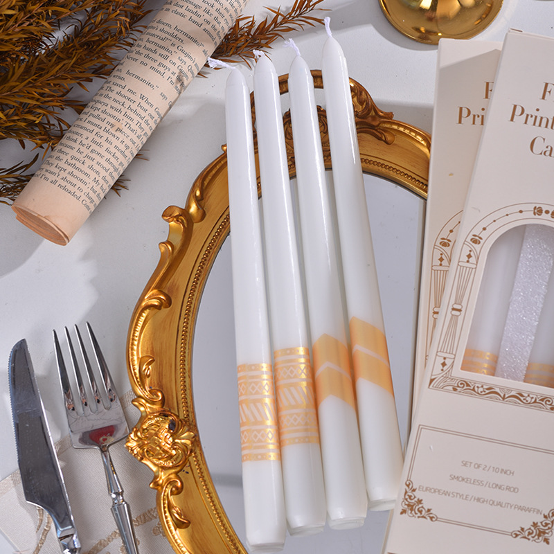 White taper candles with champagne gold patterns and packaging