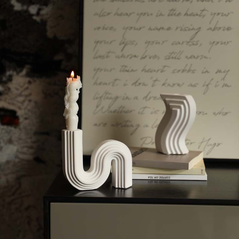 White ribbed curved porcelain candle holders styled on a cabinet