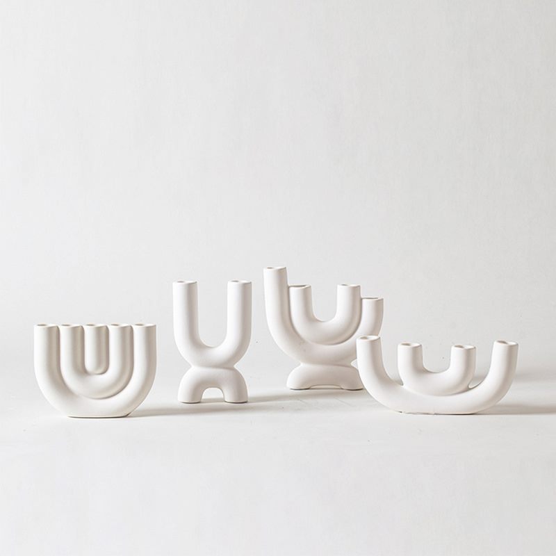 Four sculptural Nordic white porcelain candle holder designs