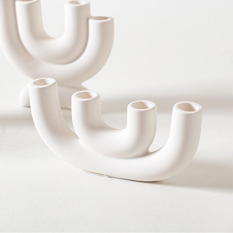 Close view of curved white porcelain candle holders