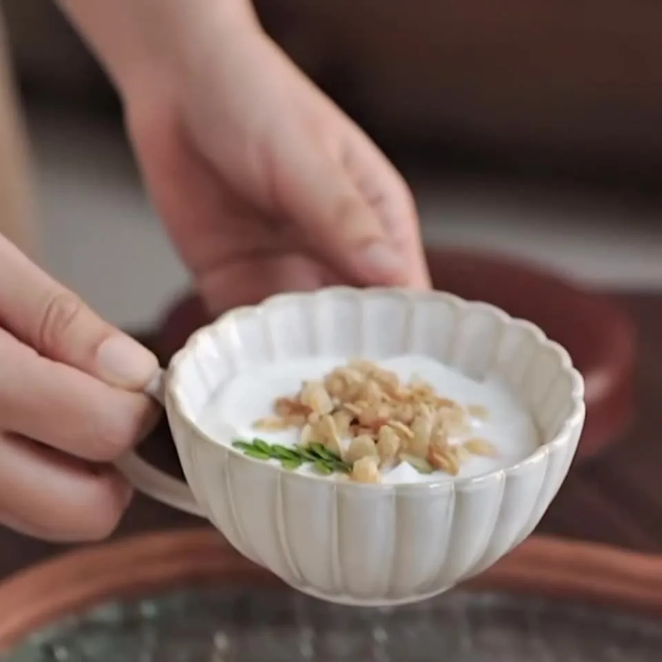 Close-up of white fluted petal ceramic cup