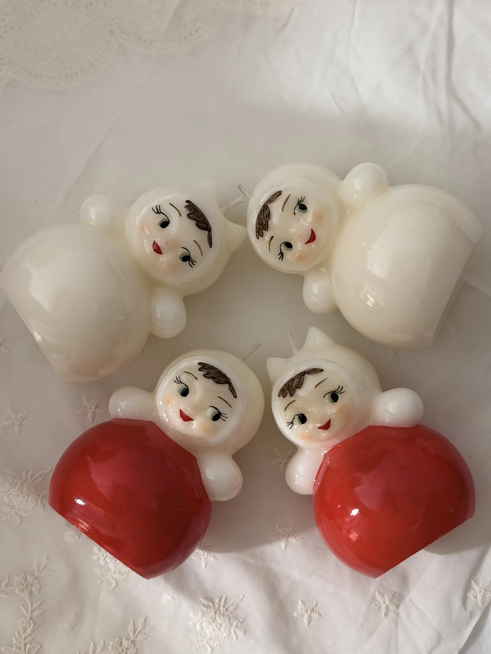 Russian doll candles arranged on white textile
