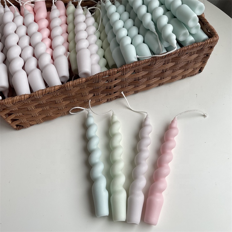 Wholesale spiral candles displayed beside a woven basket