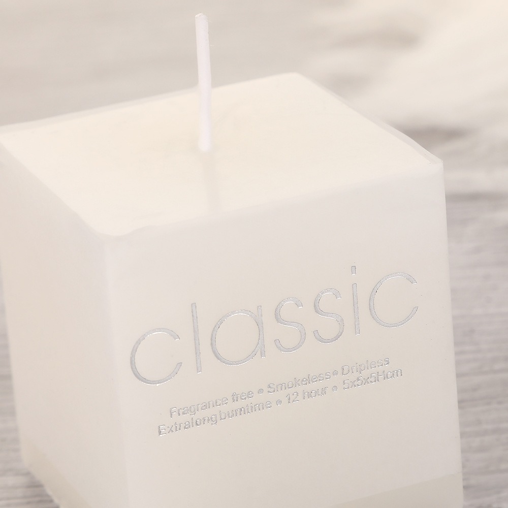 Close-up of white square candle surface and cotton wick