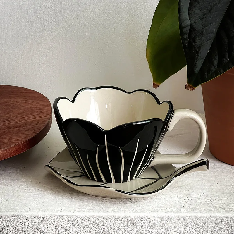 Black tulip ceramic coffee cup with white handle and leaf saucer