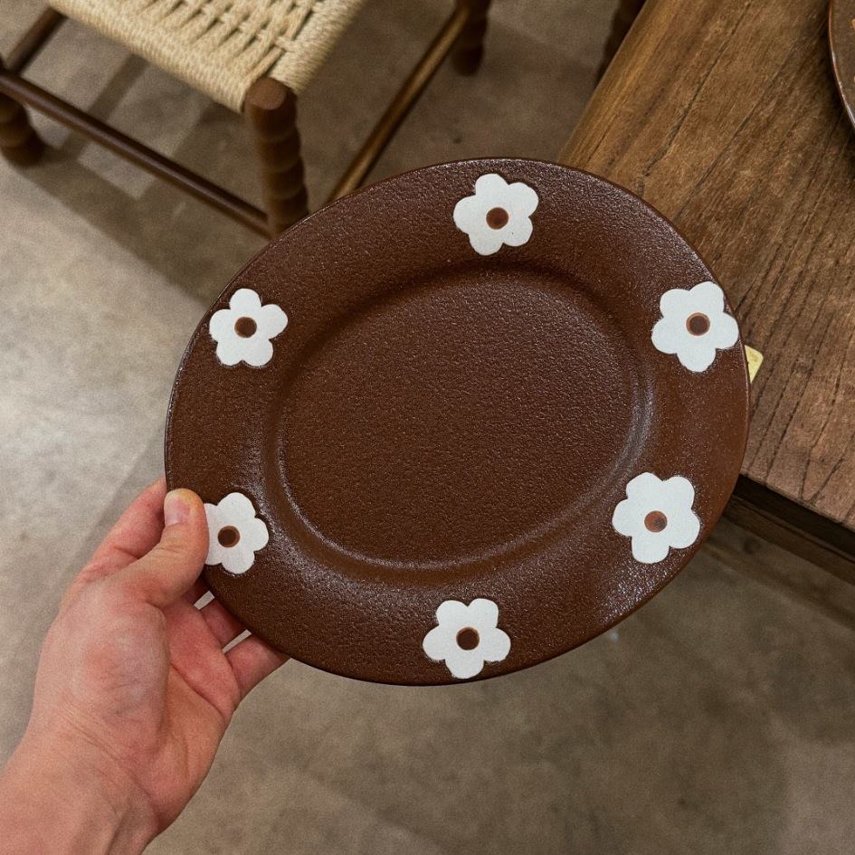 Close view of brown hand painted floral ceramic plate