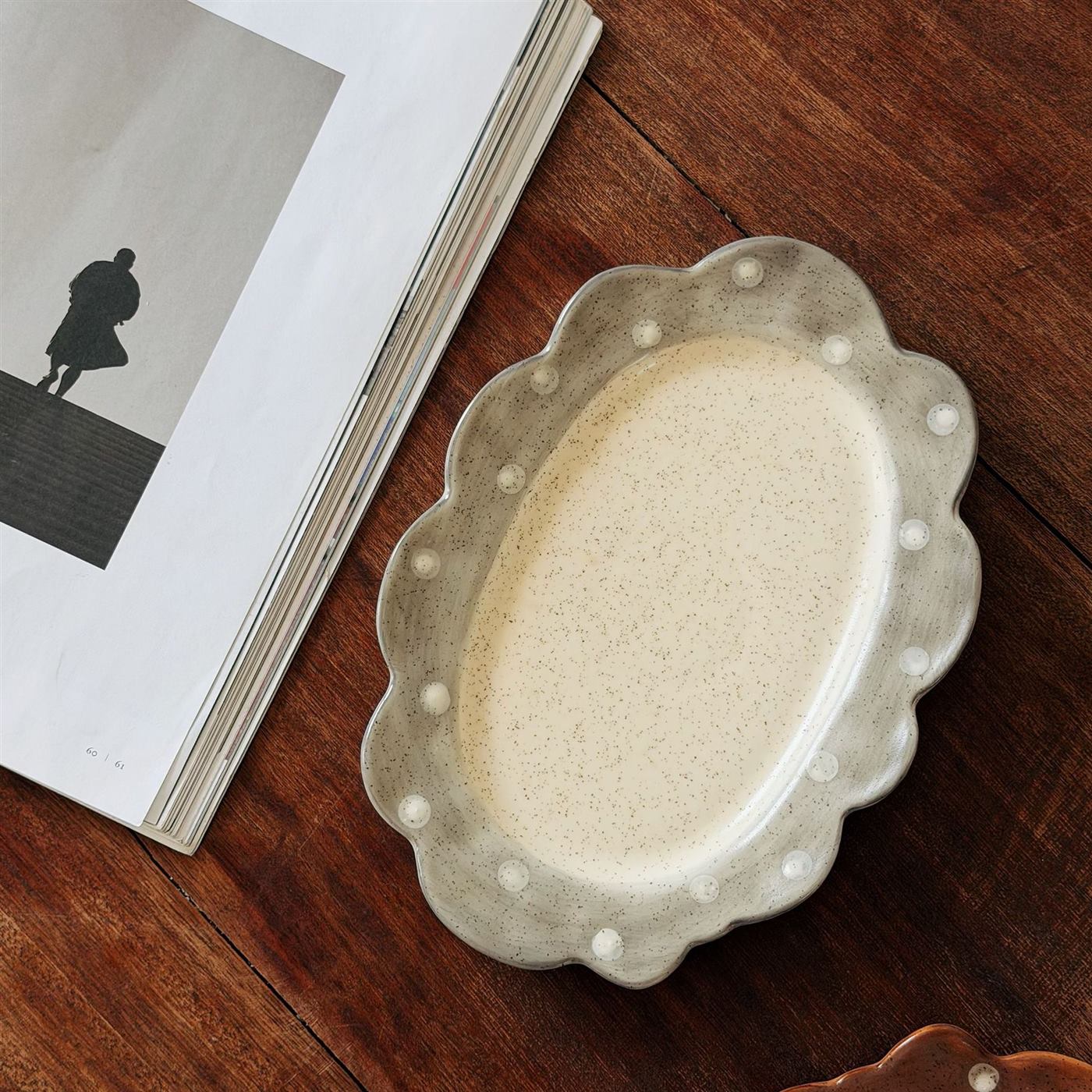 Gray scalloped ceramic serving plate with raised polka dots