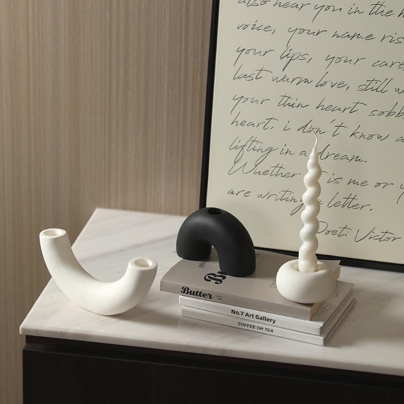Sculptural porcelain candle holders in a neutral tabletop setting